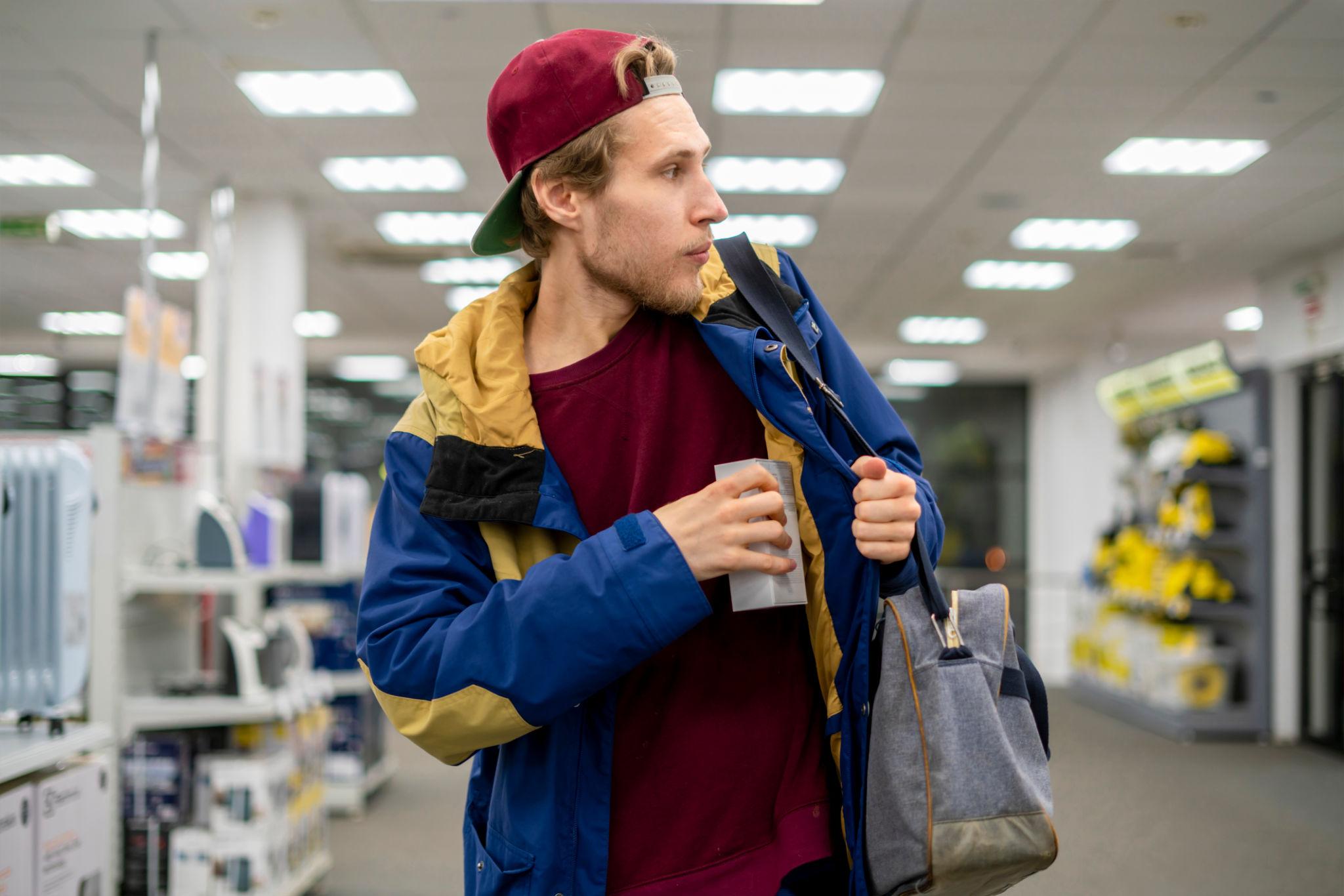shoplifter in the electronic store supermarket stealing new gadget 