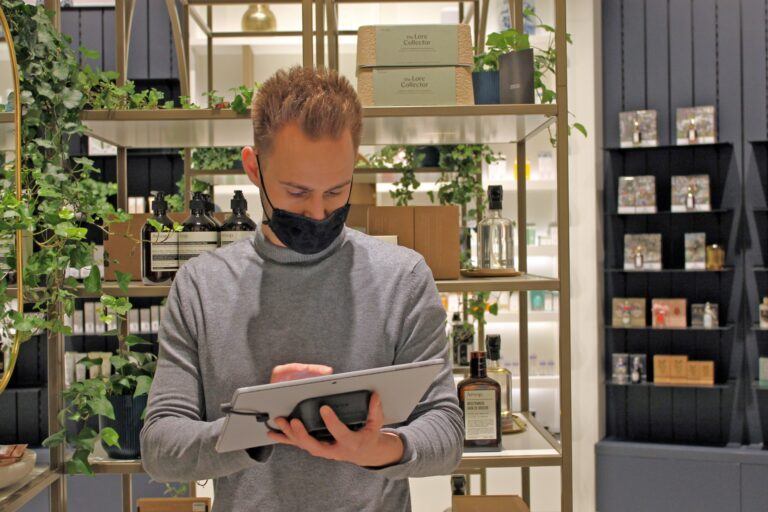 Man in mask using a NE360 tablet solution at Skins Cosmetics