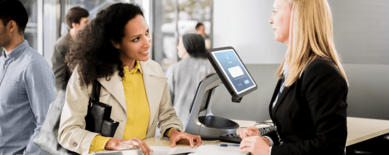 Two women speaking next to a secure tablet stand