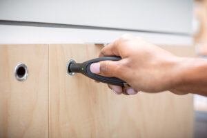 Associate using an InVue OneKEY to unlock a secured retail cabinet, demonstrating access control.