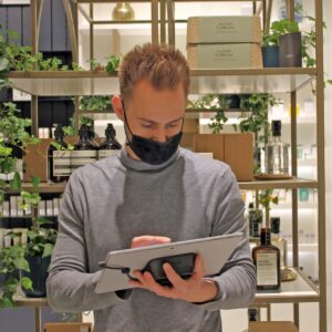 Man in mask holding mobile tablet stand