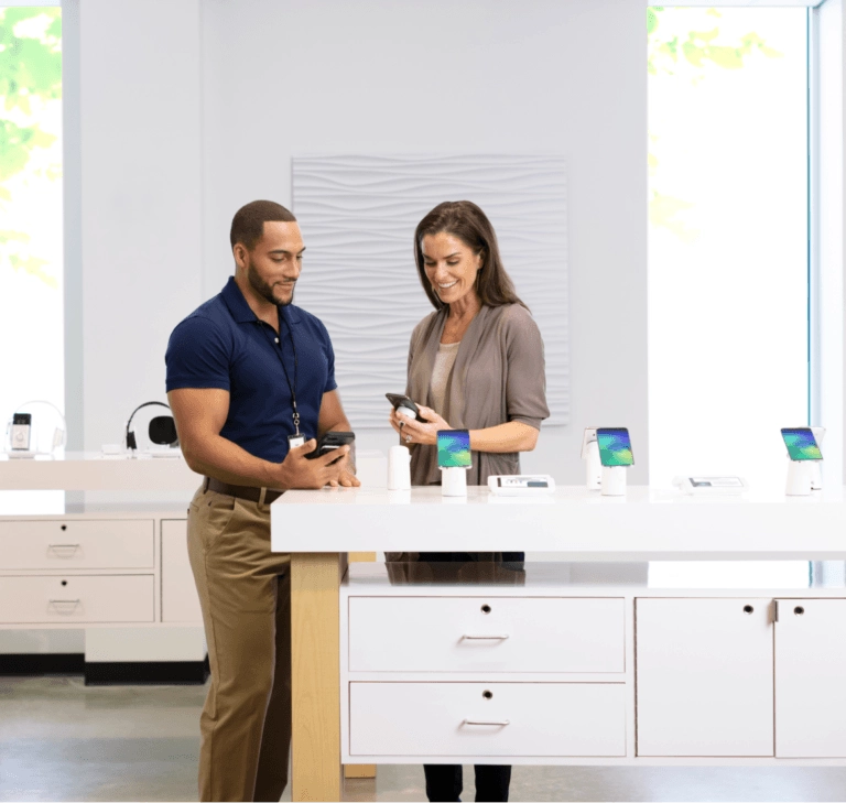 Male and female looking at mobile devices in a retail setting