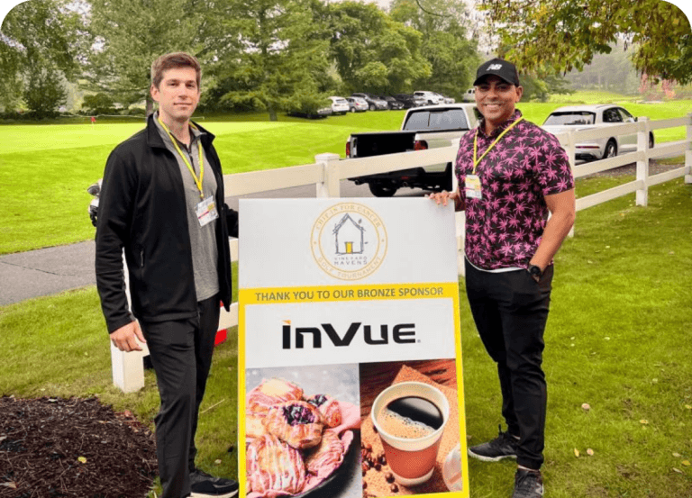 Two male InVue employees standing with sign