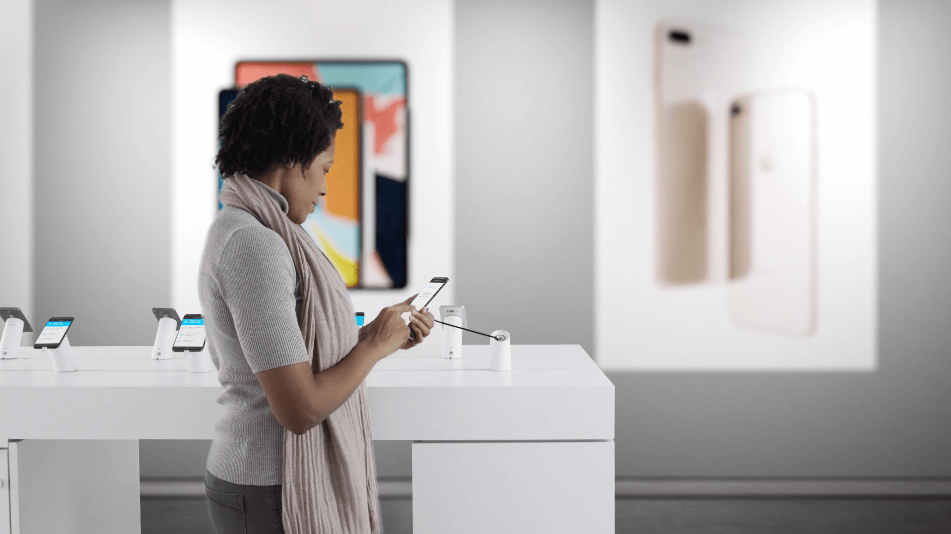 A woman looking at secure cell phones in a retail mobile carrier