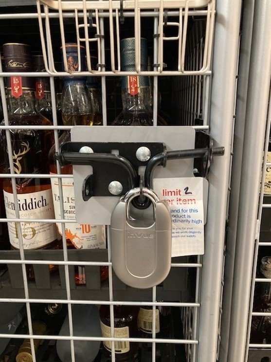 Padlock protecting liquor bottles in a cage in a Meijer store