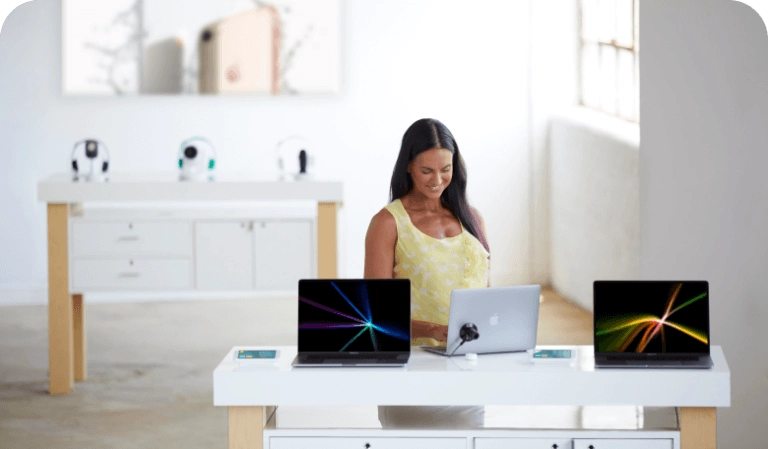 Woman looking at laptops on a table in a mobile carrier store