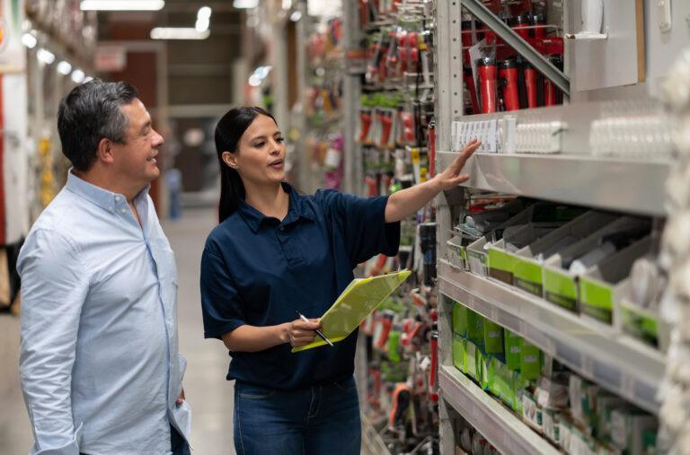 Man shopping at a home improvement store and talking to a saleswoman