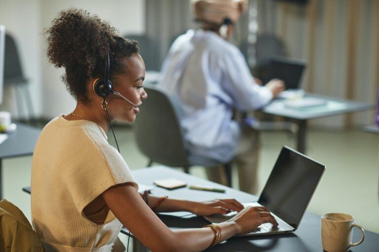 Woman sitting at a laptop with a customer service headset