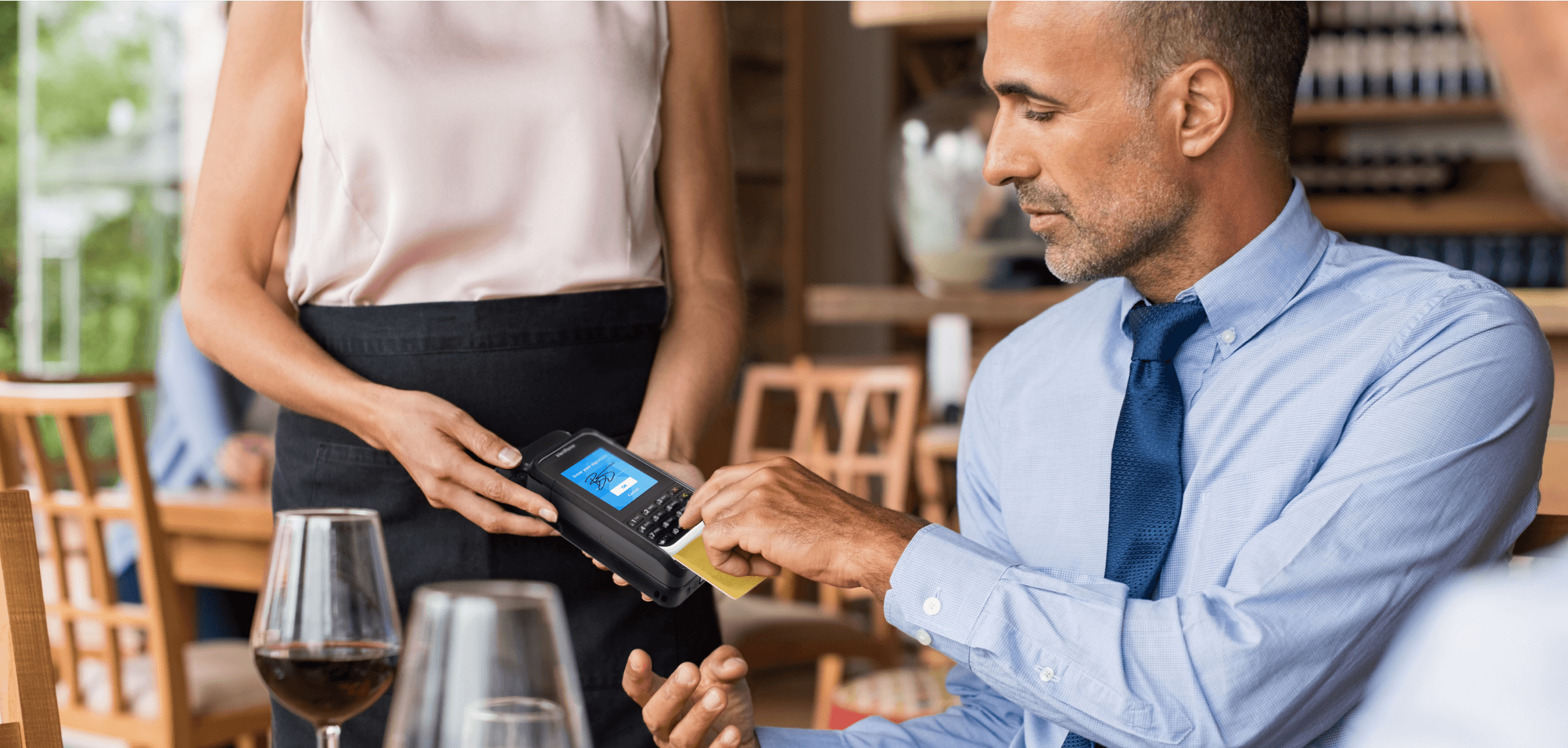 Man using mPOS Handheld Case to complete payment at a restaurant.