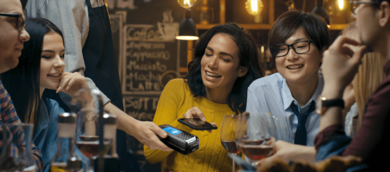 Group of people sitting with wine glasses and mPOS