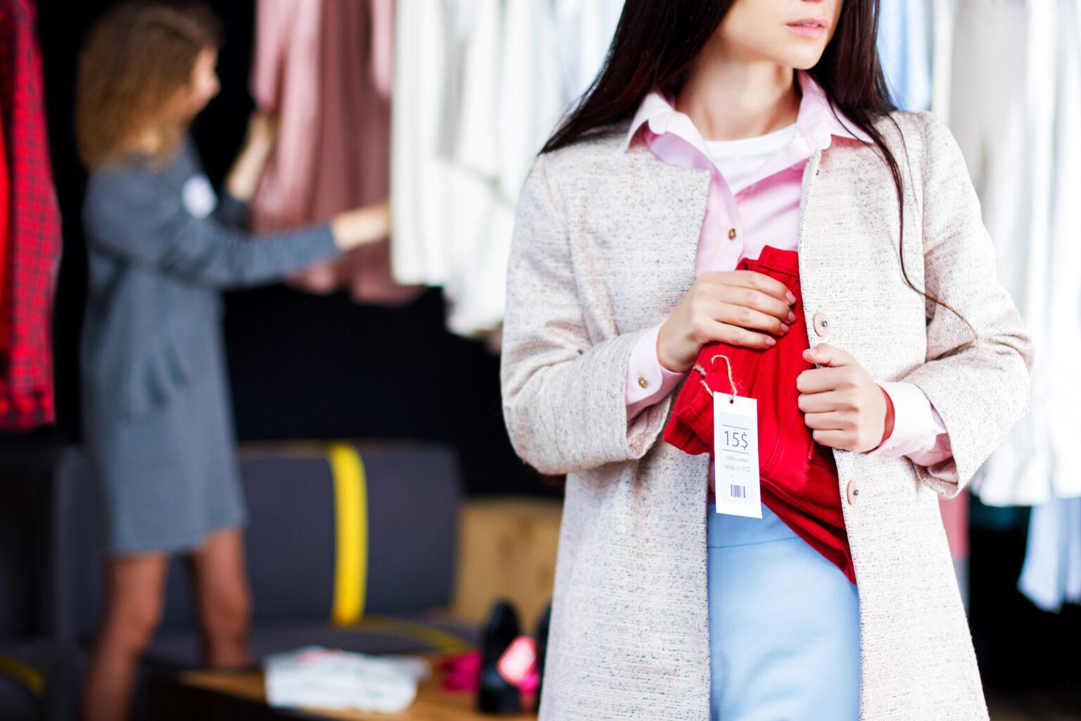 Closeup of young woman is stealing red jeans