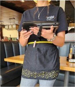 Denny's employee holding handheld device