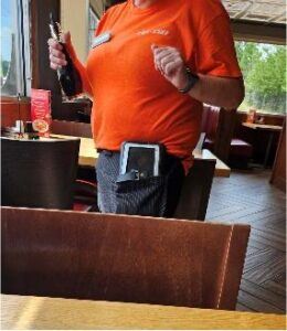 Denny's employee holding handheld device